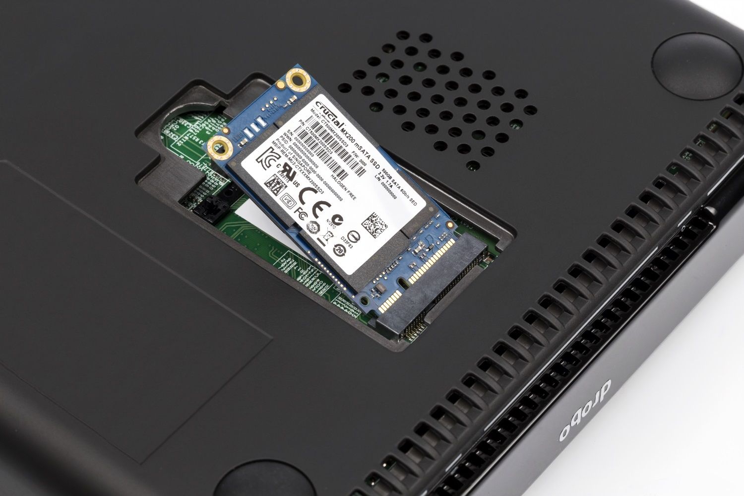 Um SSD MSATA Crucial MX200 sendo inserido em um notebook